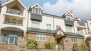 Un edificio residencial de varios pisos con fachadas de piedra y yeso, varios balcones y un cartel que indica un juzgado.