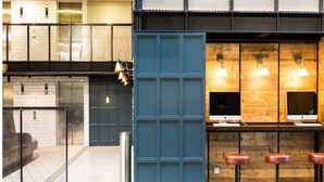 Um interior moderno com área de bar, assentos e escadaria.