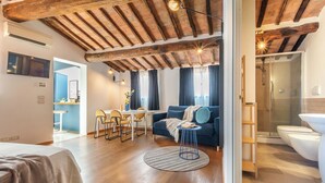Un interior moderno con techo de madera, un sofá, un comedor y un baño.