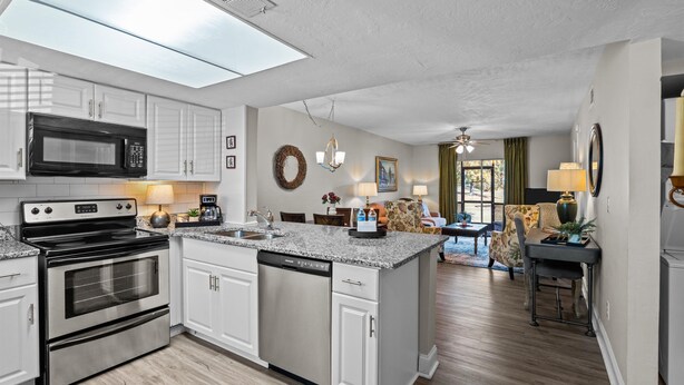 A modern kitchen with a central island, stainless steel appliances, and a dining area with a chandelier. - 2 bedroom, 2 bathroom updated condo with private patio. Centrally located in Augusta, GA (Augusta)