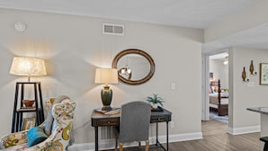A living room with a desk, chair, lamp, and a round mirror on the wall. - 2 bedroom, 2 bathroom updated condo with private patio. Centrally located in Augusta, GA (Augusta)