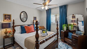 A bedroom with a four-poster bed, a ceiling fan, a bedside table with a lamp, a dresser, and a window with curtains. - 2 bedroom, 2 bathroom updated condo with private patio. Centrally located in Augusta, GA (Augusta)