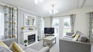 Ein Wohnzimmer mit Kamin, Fernseher und zwei Sofas.