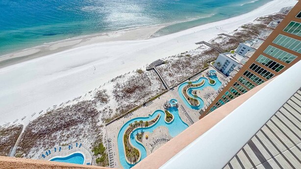 Ein Resort mit Strand, Poolbereich und einem mehrstöckigen Gebäude.