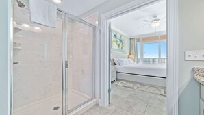 Ein modernes Badezimmer mit Duschkabine aus Glas, sichtbarer Toilette und Badewanne.