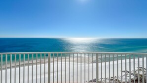 Ein Balkon mit Blick auf Strand und Meer.
