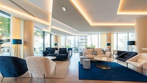 A spacious lobby with modern furniture, large windows, and a view of the city. - Jupiter Porto Hotel - Rooftop & Spa (Porto)
