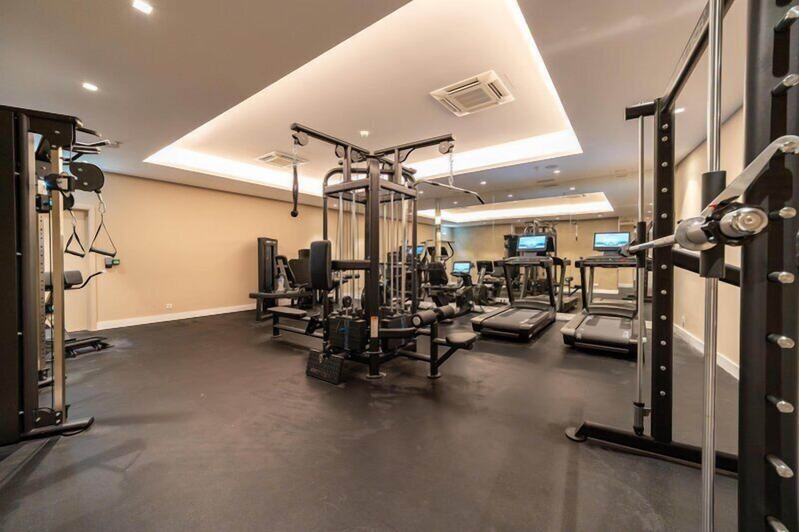 A gym with weightlifting equipment, treadmills, and exercise machines.