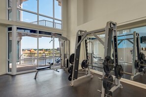 Ein Fitnessstudio mit Gewichtstrainingsgeräten und großen Fenstern mit Blick auf eine schöne Landschaft.