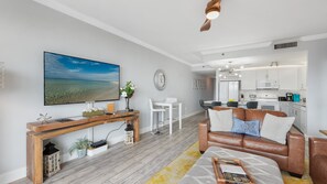 Ein modernes Wohnzimmer mit einem Holzkonsolentisch, einem weißen Sofa und einem großen Flachbildfernseher.