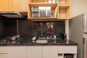 Apartamento luxo, vista para a cidade | Cozinha privada | Geladeira, micro-ondas, cooktop, talheres/pratos/utensílios de cozinha