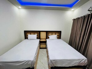 A room with two single beds, a wooden headboard, a ceiling light, and a curtain. - Rose Hotel Hurghada 2 (Hurghada)