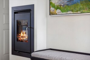 A room with a fireplace, a bed, and a painting on the wall. - Appartment by the sea and family friendly beach (Bagenkop)