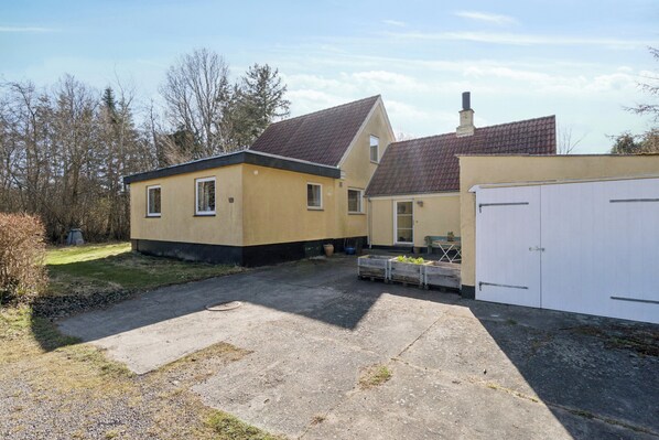 A residential property with a detached house, a garage, and a paved driveway.