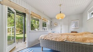 Een slaapkamer met een bed, een raam, een deur en een plafondlamp.