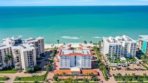 Un hôtel situé sur la côte, composé de plusieurs bâtiments, avec une plage et une vue sur l’océan.