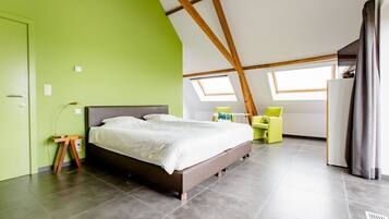 Un dormitorio moderno con una cama grande, ventanas de tragaluz y una pared de acento verde.
