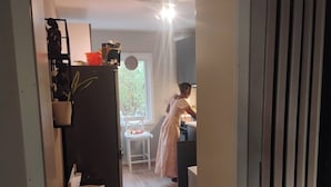 Et køkken med et køleskab, en stol og et vindue.