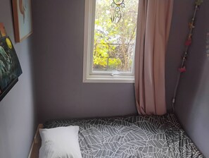 A bedroom with a single bed, a window with curtains, and a wall-mounted dreamcatcher. - Nicely Decorated House Near Forest and Town (Oslo)