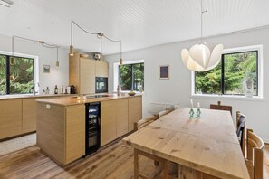 Een moderne keuken met houten kastjes, een centraal eiland en hanglampen.