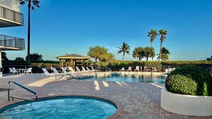 A swimming pool with lounge chairs and a gazebo. - Oceanfront Sanctuary with 3 bedrooms (Fort Pierce)