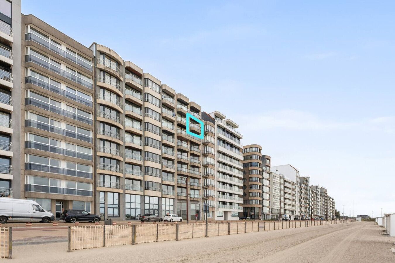 A multi-story residential building with a modern architectural design, featuring balconies and large windows.