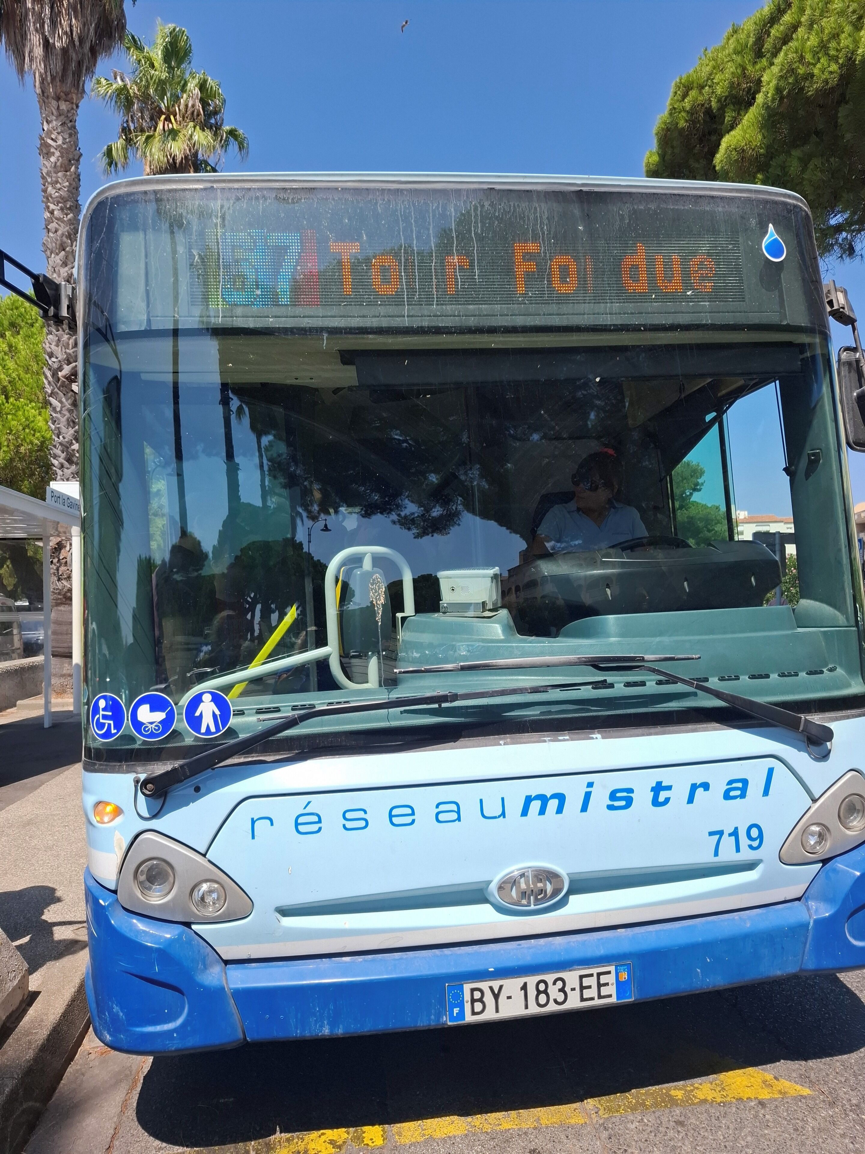A public bus with a digital display reading "Tour F1 due" and the destination "Port La Garde".