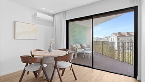 Un apartamento moderno con balcón, una mesa de comedor redonda y vistas a la ciudad.