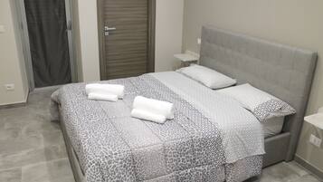 A bedroom with a bed, two bedside tables, and a door.