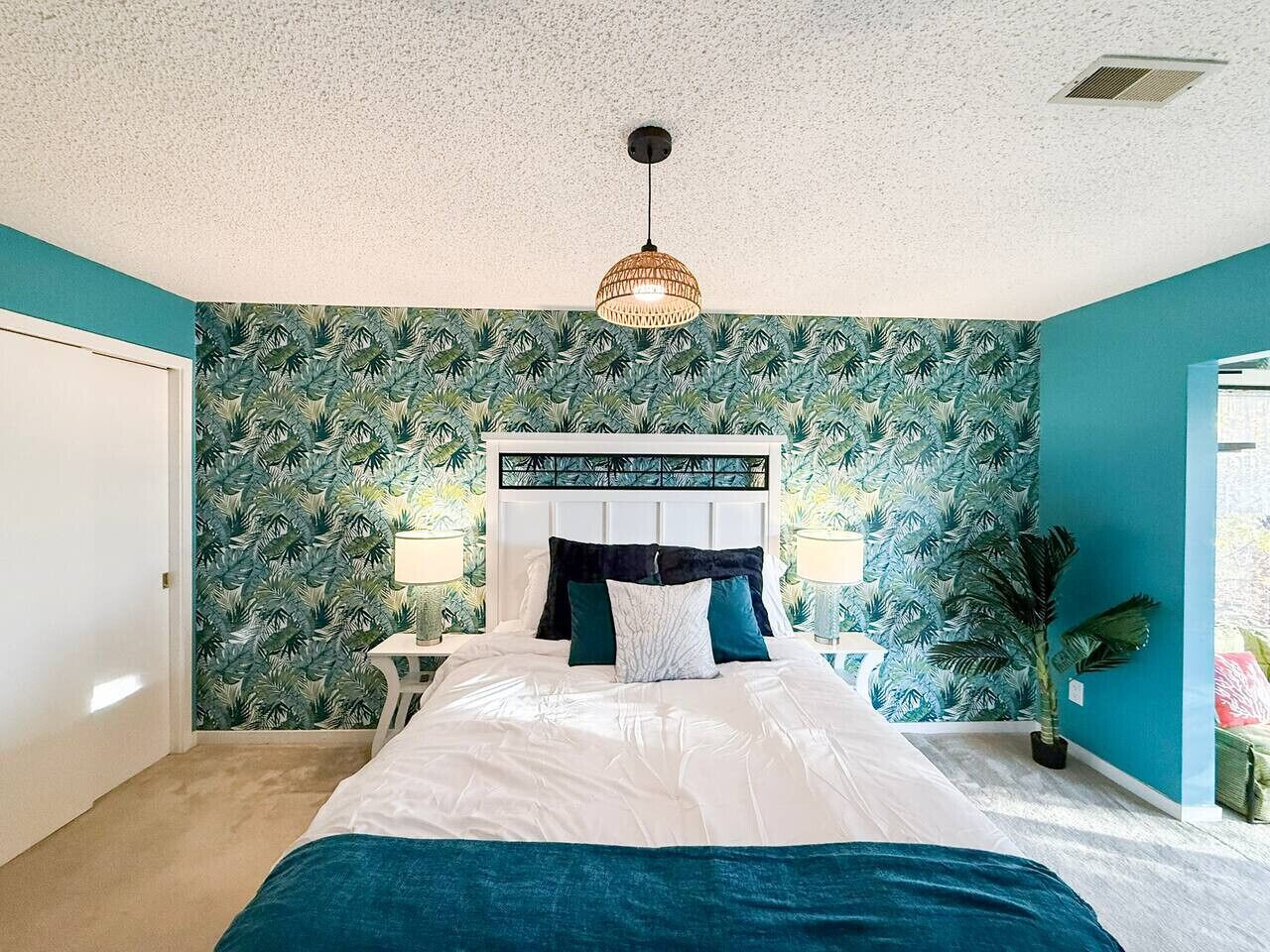 A bedroom with a bed, a nightstand, a lamp, and a ceiling light.