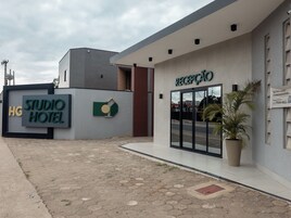 Entrada moderna de hotel com balcão de recepção, placa indicativa e logotipo.