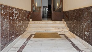 A marble staircase with a wooden door leading to a room. - Versailles | The Rentals Collection (San Sebastián/Donostia)
