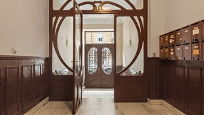 A grand entrance with a wooden door, a view of the street, and a row of wooden lockers on the right. - Versailles | The Rentals Collection (San Sebastián/Donostia)