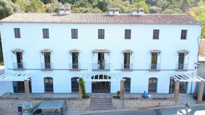 A two-story building with a tiled roof, multiple balconies, and a central entrance with steps. - Hotel Rural Mirador de Jubrique (Jubrique)