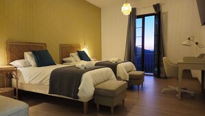 A hotel room with two beds, a desk, and a view of the outdoors. - Hotel Rural Mirador de Jubrique (Jubrique)