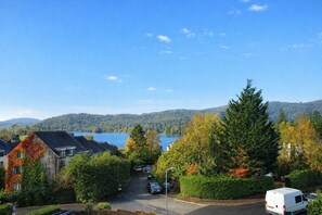 A residential area with houses, a road, and a lake in the background. - Molly's Mews, Bowness on Windermere, with lake view (Bowness on Windermere)