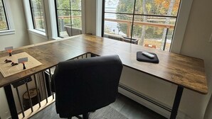 Een kamer met een groot raam, een bureau en een stoel.