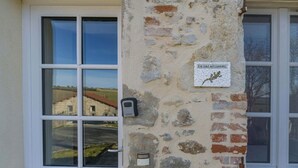 A stone wall with a sign reading "La Salamandre" and a window with a view of a building. - Gîte de caractère Charroux La Samandre (Charroux)