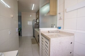Eine moderne Küche mit einer Granitabdeckung, Edelstahlgeräten und einer gefliesten Spritzschutzwand.
