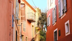 Uma rua estreita com escadas que levam a um edifício com varanda.