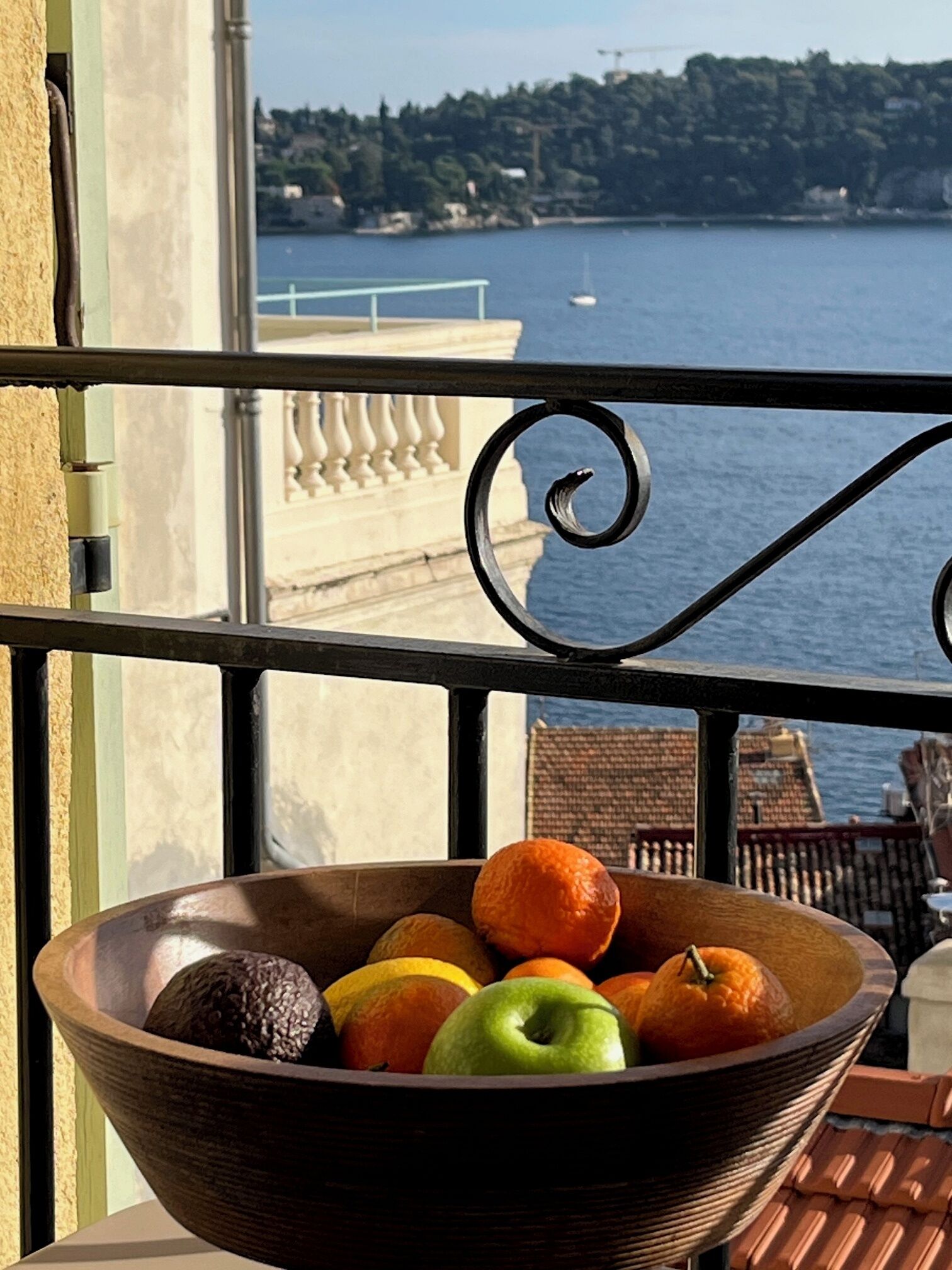 Ein Balkon mit Blick auf ein Gewässer und eine entfernte Küste.