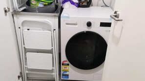 En tvättmaskin med frontmatning, det vill säga med luckan på framsidan, en kontrollpanel och en etikett som anger vattenförbrukningen.
