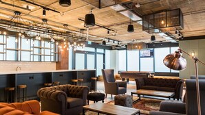 A modern lounge area with seating, a pool table, and industrial-style lighting. - Student Luxury Studio Aldgate Residence (London)