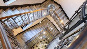 Eine mehrgeschossige Treppe mit aufwendiger Metallgalerie und einer Kristallleuchtre.