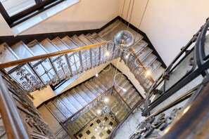 Eine mehrgeschossige Treppe mit aufwendiger Metallgalerie und einer Kristallleuchtre.