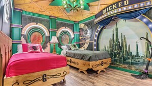 Ein Zimmer mit zwei Holzbetten, einer großen, runden Wanduhr und einem Wandgemälde einer Stadtansicht.
