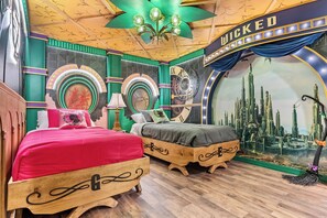 A room with two wooden beds, a large circular wall clock, and a mural of a cityscape. - 10BR house sleeps 23 with game room (Clermont)