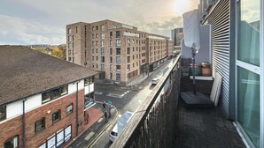 A multi-story building with a brick facade, a visible entrance, and a street in front. - Charming Central Studio with Balcony in Birmingham (West Midlands)