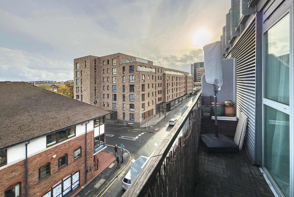 A multi-story building with a brick facade, a visible entrance, and a street in front. - Charming Central Studio with Balcony in Birmingham (West Midlands)