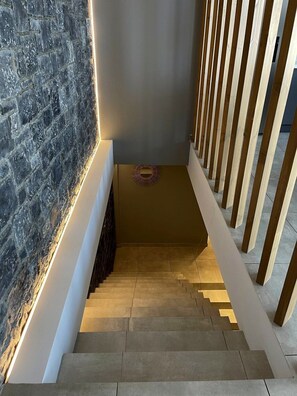 Eine Treppe mit einer Marmorwand auf der einen Seite und einem Holzgeländer auf der anderen.